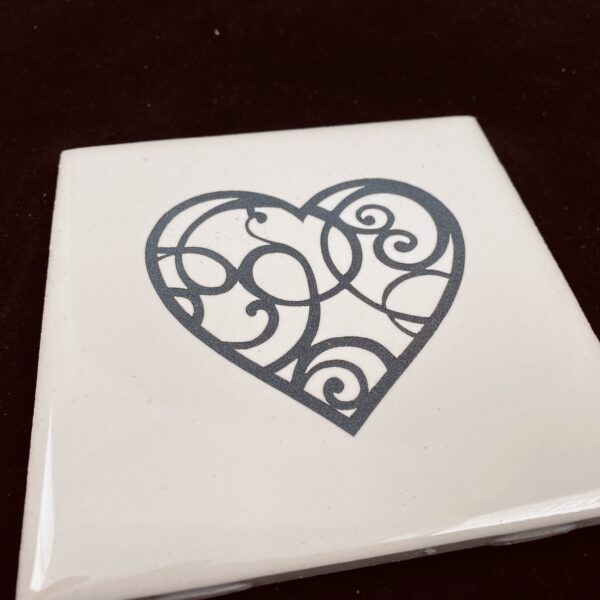 Image of engraved white coasters with decorative heart design - Donley Woodworking