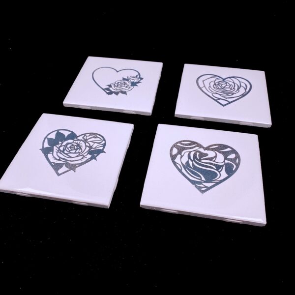 Image of engraved white coasters with decorative heart design - Donley Woodworking