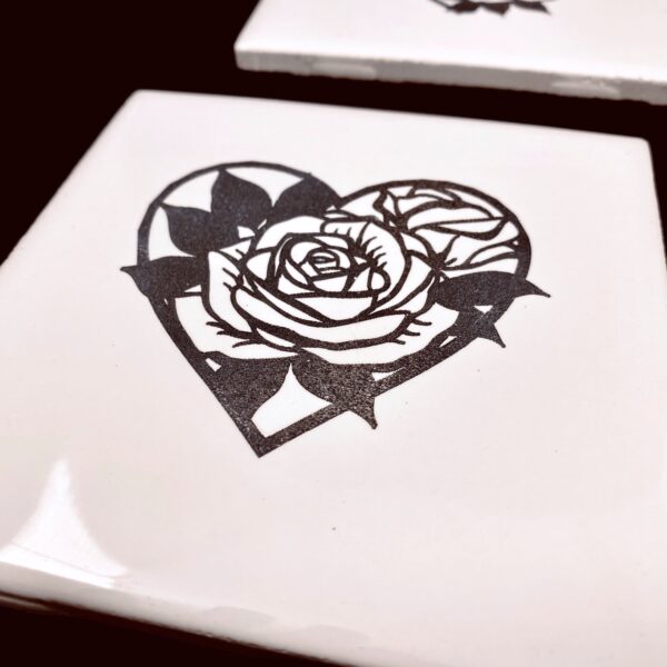 Image of engraved white coasters with decorative flower heart design - Donley Woodworking