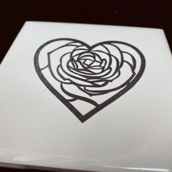 Image of engraved white coasters with decorative flower heart design - Donley Woodworking